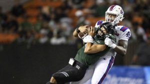 Jaylon Ferguson tackling a Hawaii player.