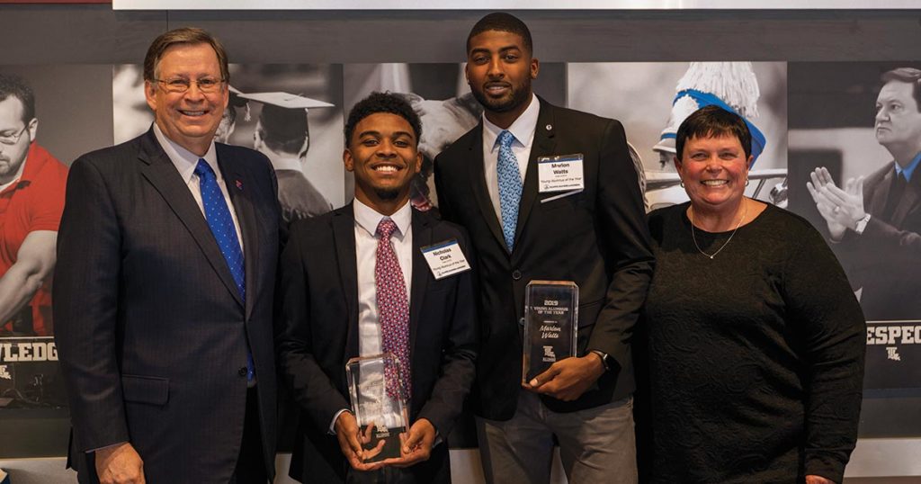 Dr. Guice and Cathi Cox-Boniol present Nicholas Clark and Marlon Watts with the Young Alumni of the Year award.