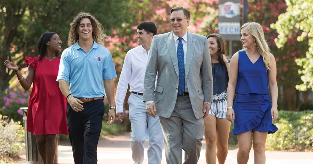 Dr. Guice walking with students in Centennial Plaza.