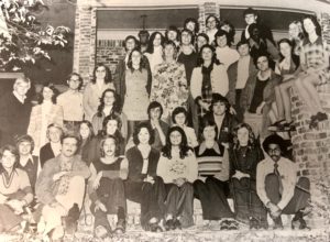 Several students posing for a photo at the president's home.