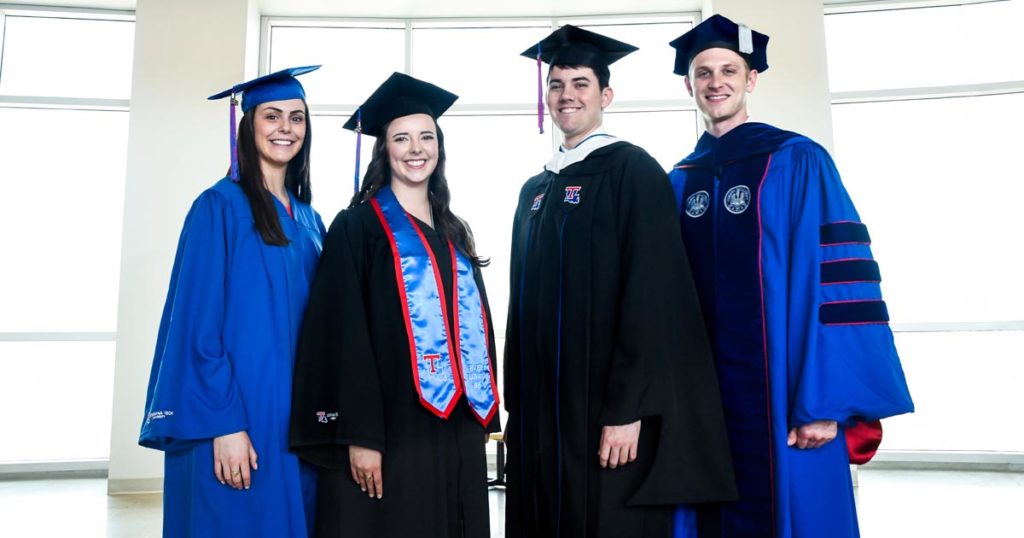 Four students modeling Louisiana Tech's new commencement regalia.