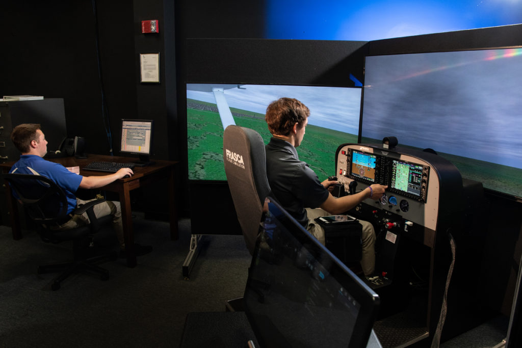 An aviation student trains for flight using a simulator in Davison Hall