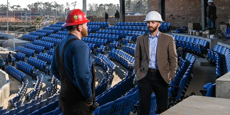 Adam McGuirt talks with a construction worker at the baseball stadium.