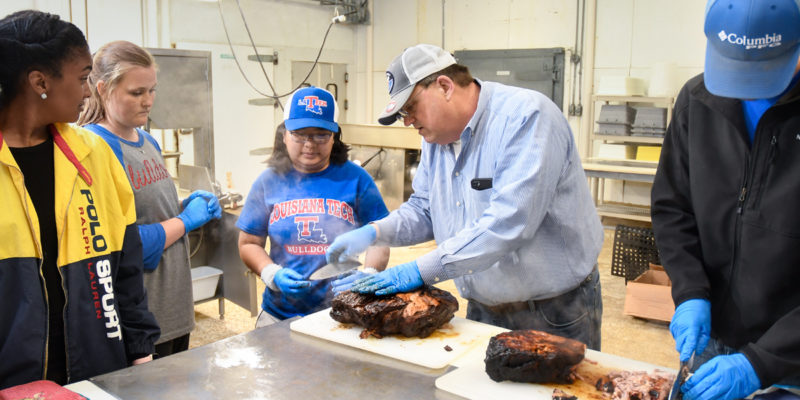 Dr. Mark Murphey works with students in the meat lab.