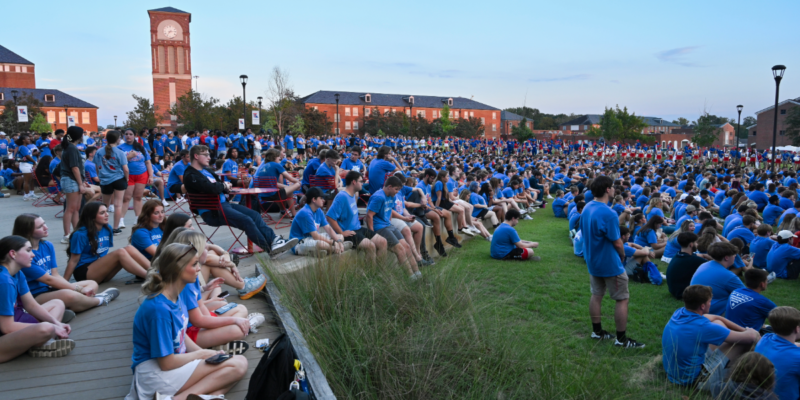 A large group of freshman sit in Centennial Plaza