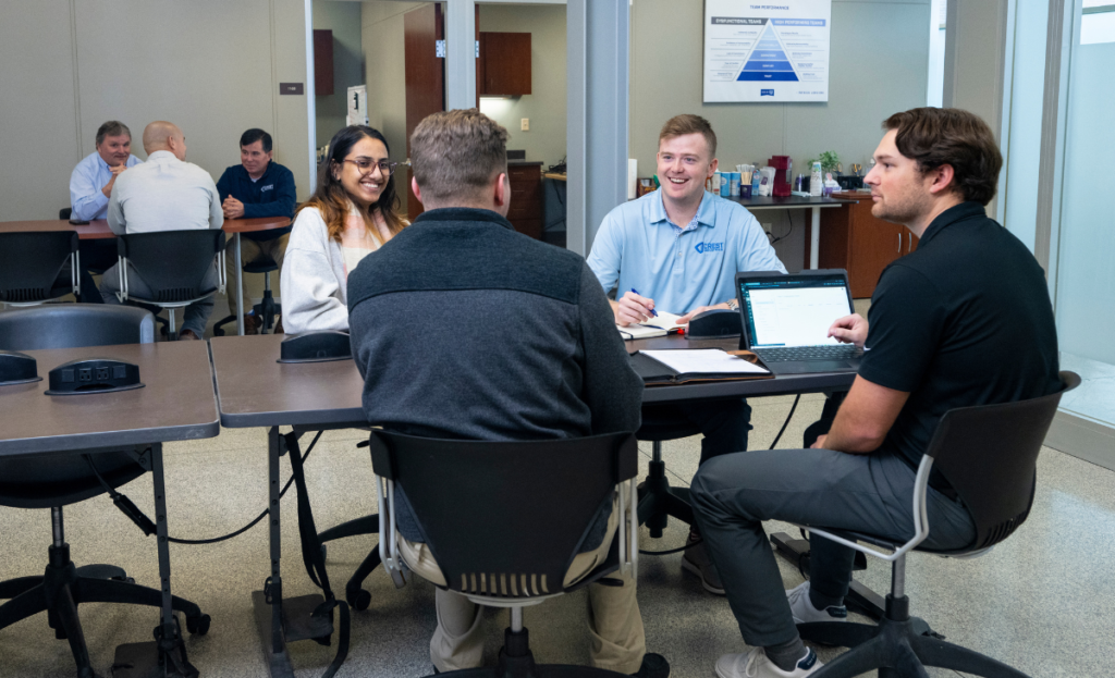 Joshua Nelson, Daylon Bozeman, and other Crest employees gathered at a table